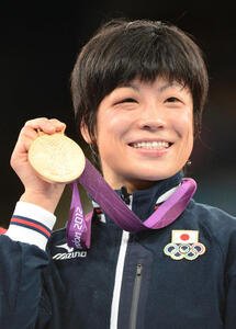 金メダルを披露し笑顔を見せる小原日登美さん(2012年8月8日)