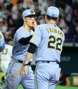 巨人対阪神　延長戦を制し、迎えた阪神藤川監督(右)とハイタッチする佐藤輝(撮影･浅見桂子)
