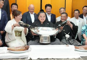 師匠の佐渡ヶ嶽親方(右)とおかみさんから銀杯にお酒を注いでもらい笑顔を見せる琴勝峰(撮影･小沢裕)