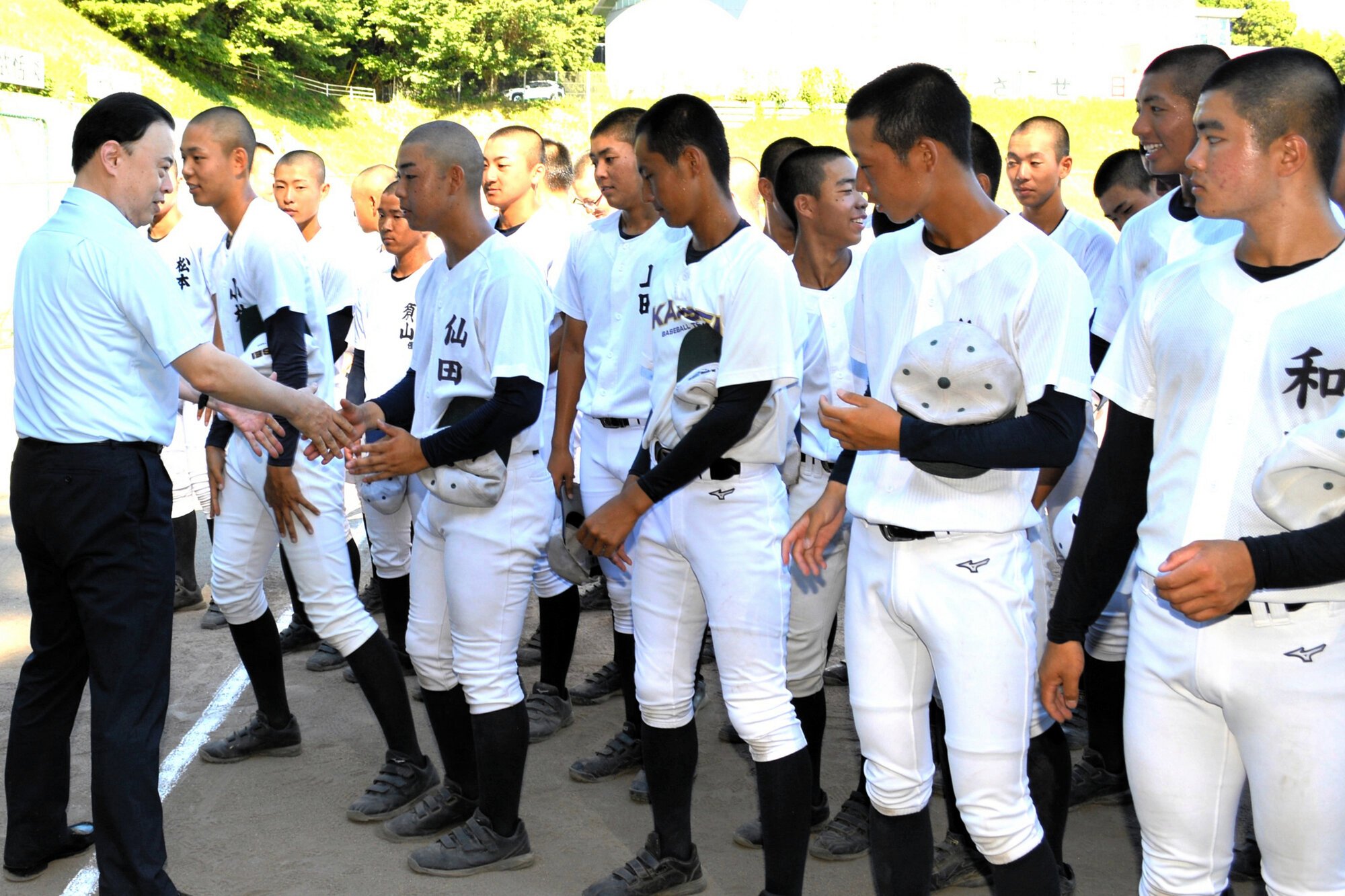 開星の選手1人ずつと握手を交わして激励する丸山達也･島根県知事(左端)=2025年7月28日午前8時23分、松江市西津田9丁目、堀田浩一撮影