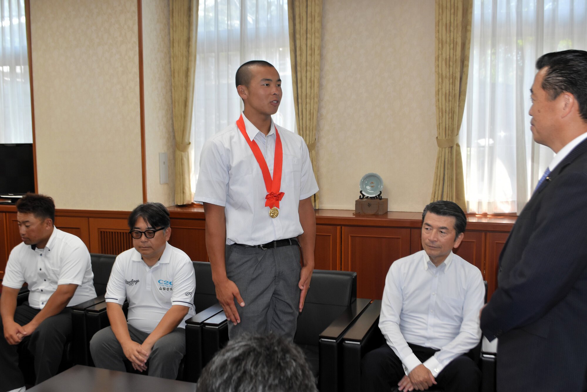 県議会の佐野弘仁副議長(右)に抱負を語る山梨学院の梅村団主将=2025年7月29日、山梨県庁、池田拓哉撮影