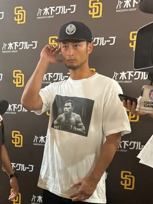 18年に亡くなった義兄の山本KID徳郁さんがプリントされたTシャツを着て囲み取材に応じるダルビッシュ