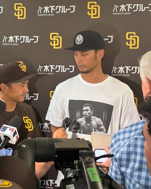 18年に亡くなった義兄の山本KID徳郁さんがプリントされたTシャツを着て囲み取材に応じるダルビッシュ