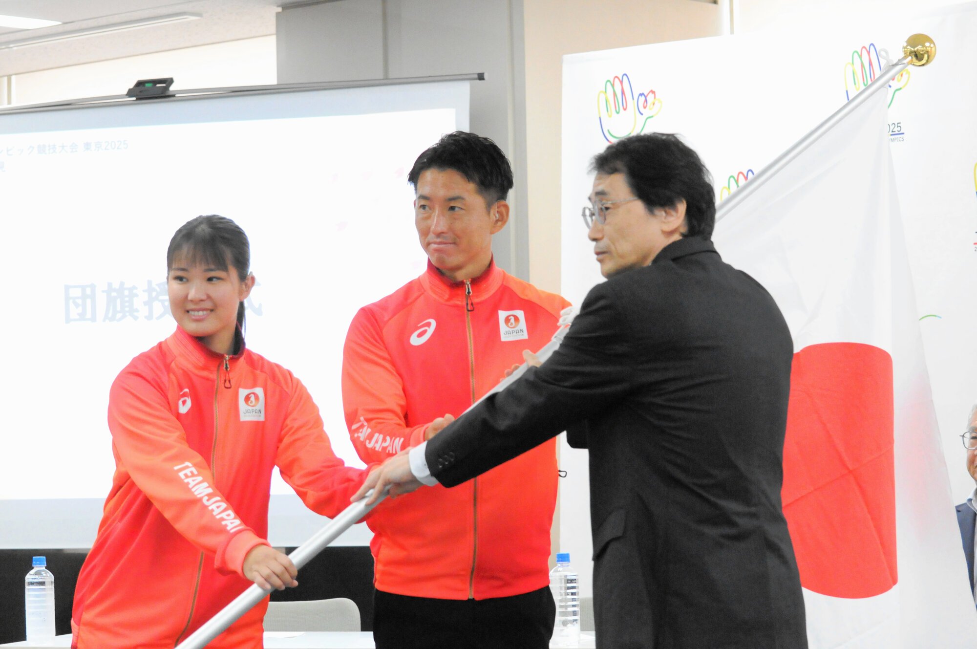 デフリンピック日本選手団の旗手に指名された空手女子の小倉涼(左)とサッカー男子の松元卓巳(中央)