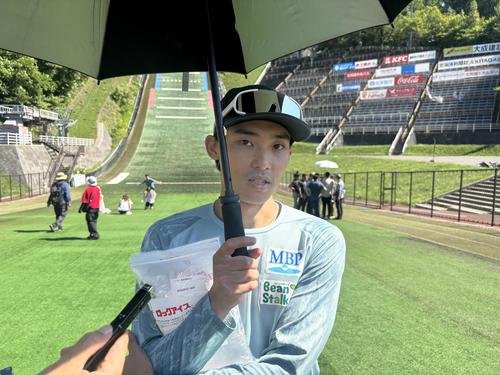 今季初優勝した小林朔は氷を抱えながら、傘をさして取材に対応する(撮影･保坂果那)