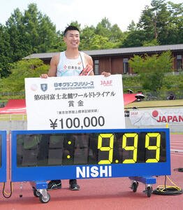 世界選手権標準記録を突破し、記念のボードを手に笑顔を見せる桐生(撮影･足立雅史)