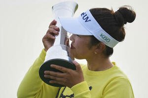全英女子オープンの優勝トロフィーにキスをする山下美夢有(AP)