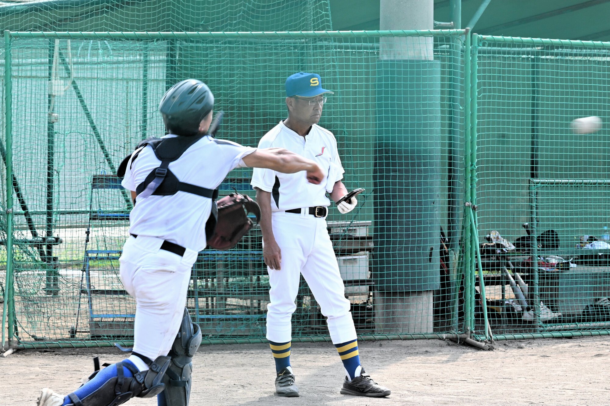 内野連係でスピードを計測する斎藤監督=2025年8月4日午前10時9分、兵庫県稲美町の県立東播磨高校、荒川公治撮影
