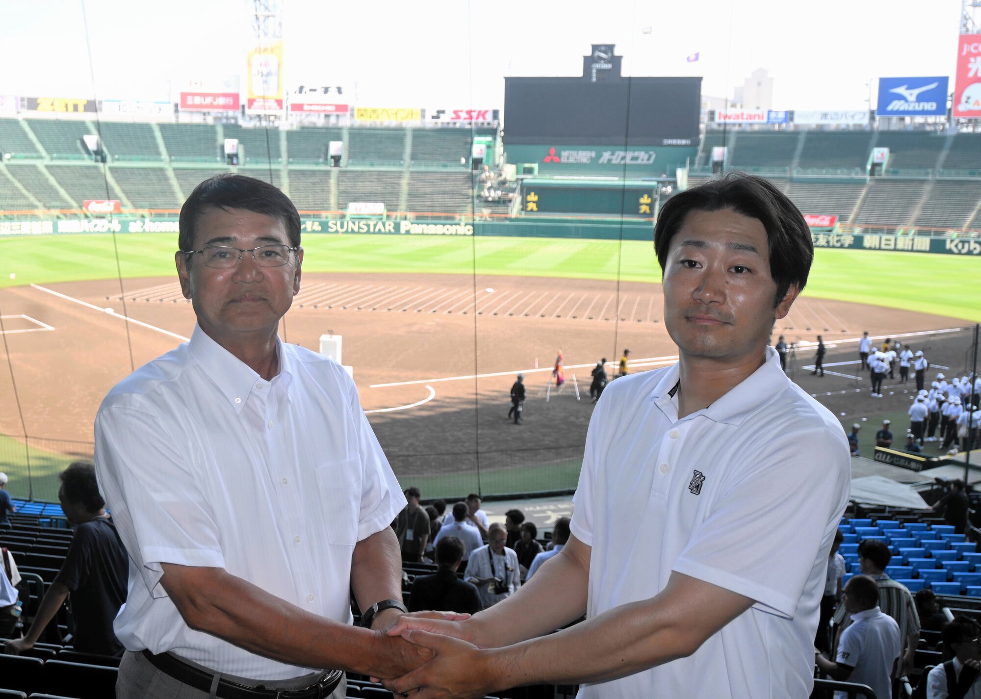 監督対談で握手する鳴門の岡田将和監督(右)と天理の藤原忠理監督=2025年8月4日午後3時49分、阪神甲子園球場、鈴木史撮影