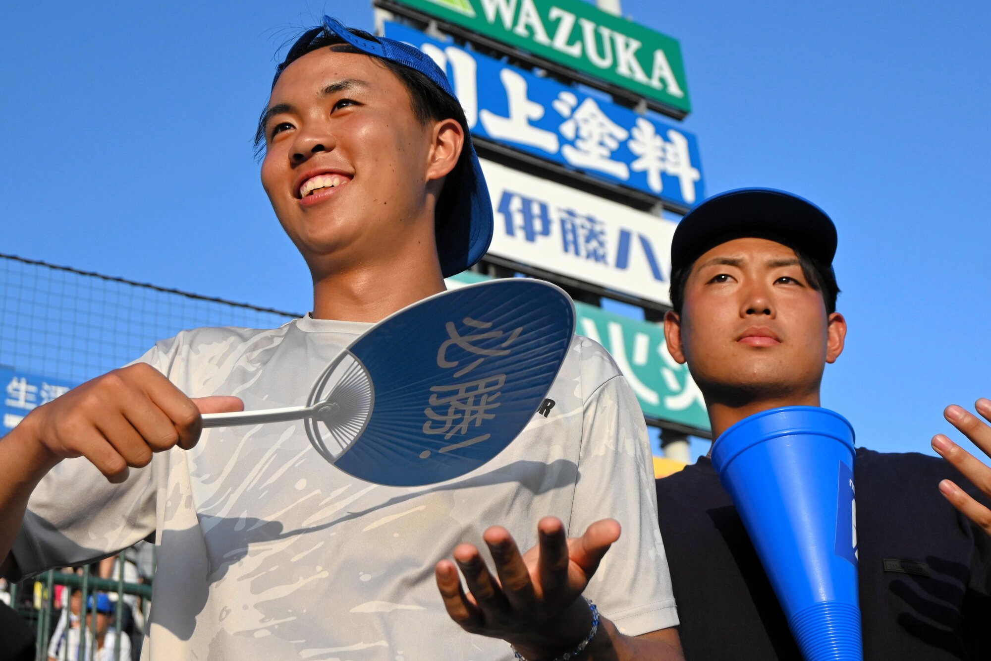 アルプス席から応援する小松大谷卒業生の西川大智さん(左)と東野達さん=2025年8月5日午後6時2分、阪神甲子園球場、砂山風磨撮影