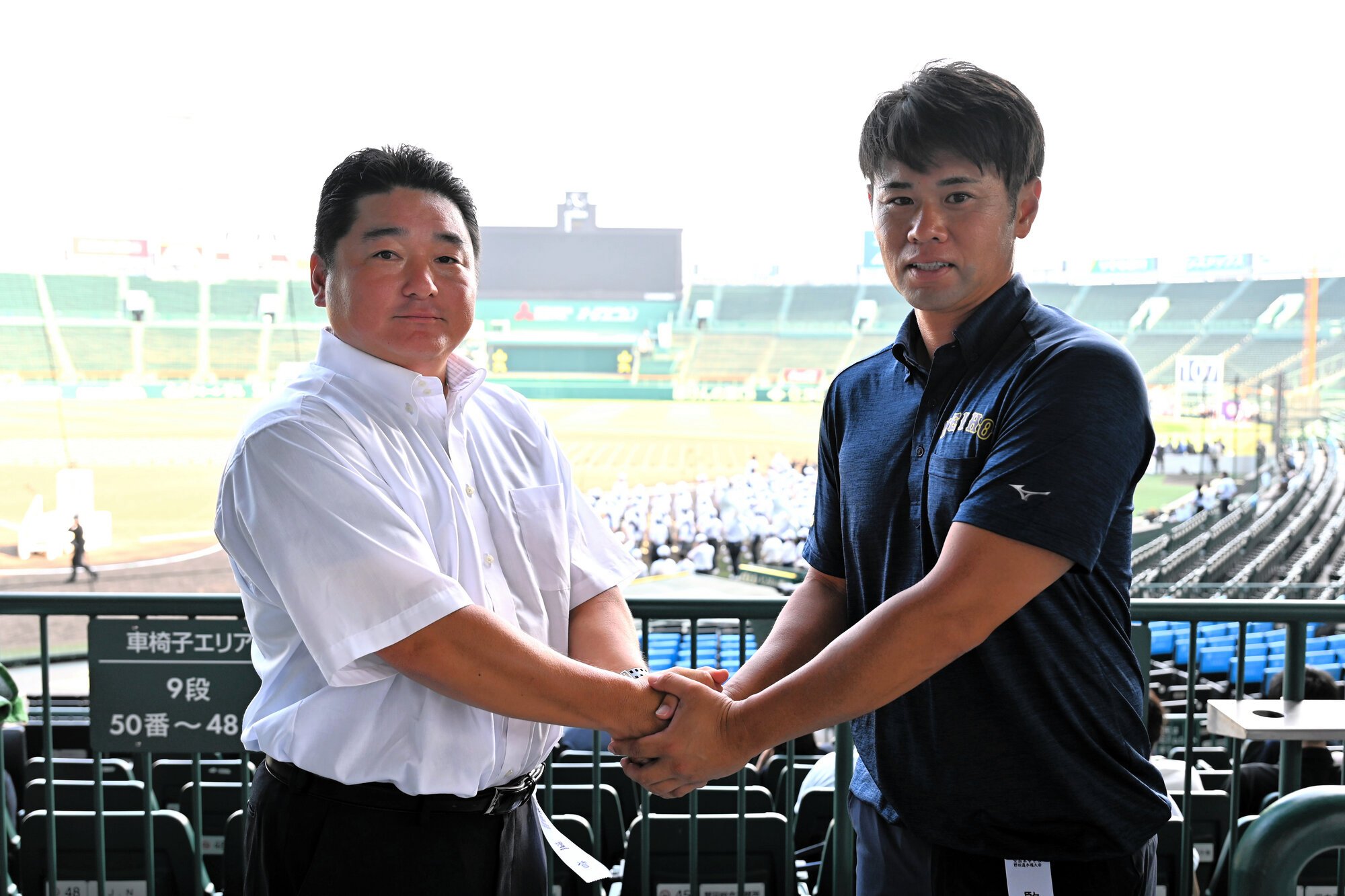 握手を交わす市船橋･海上雄大監督(左)と明豊･川崎絢平監督=2025年8月4日午後3時56分、阪神甲子園球場、大村久撮影