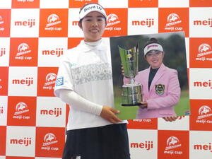 関西運動記者クラブ･ゴルフ分科会から昨季の優秀選手賞の表彰を受け、受け取った写真パネルを手に笑顔の山下