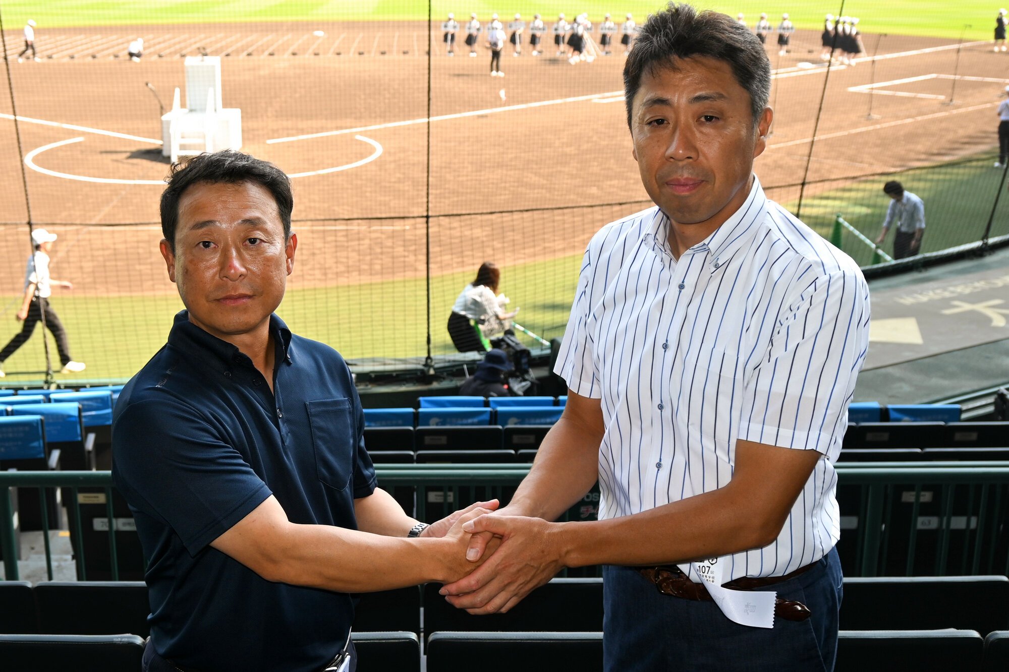 握手を交わす東海大熊本星翔の野仲義高監督と北海の平川敦監督(右)=2025年8月4日、阪神甲子園球場、朽木誠一郎撮影