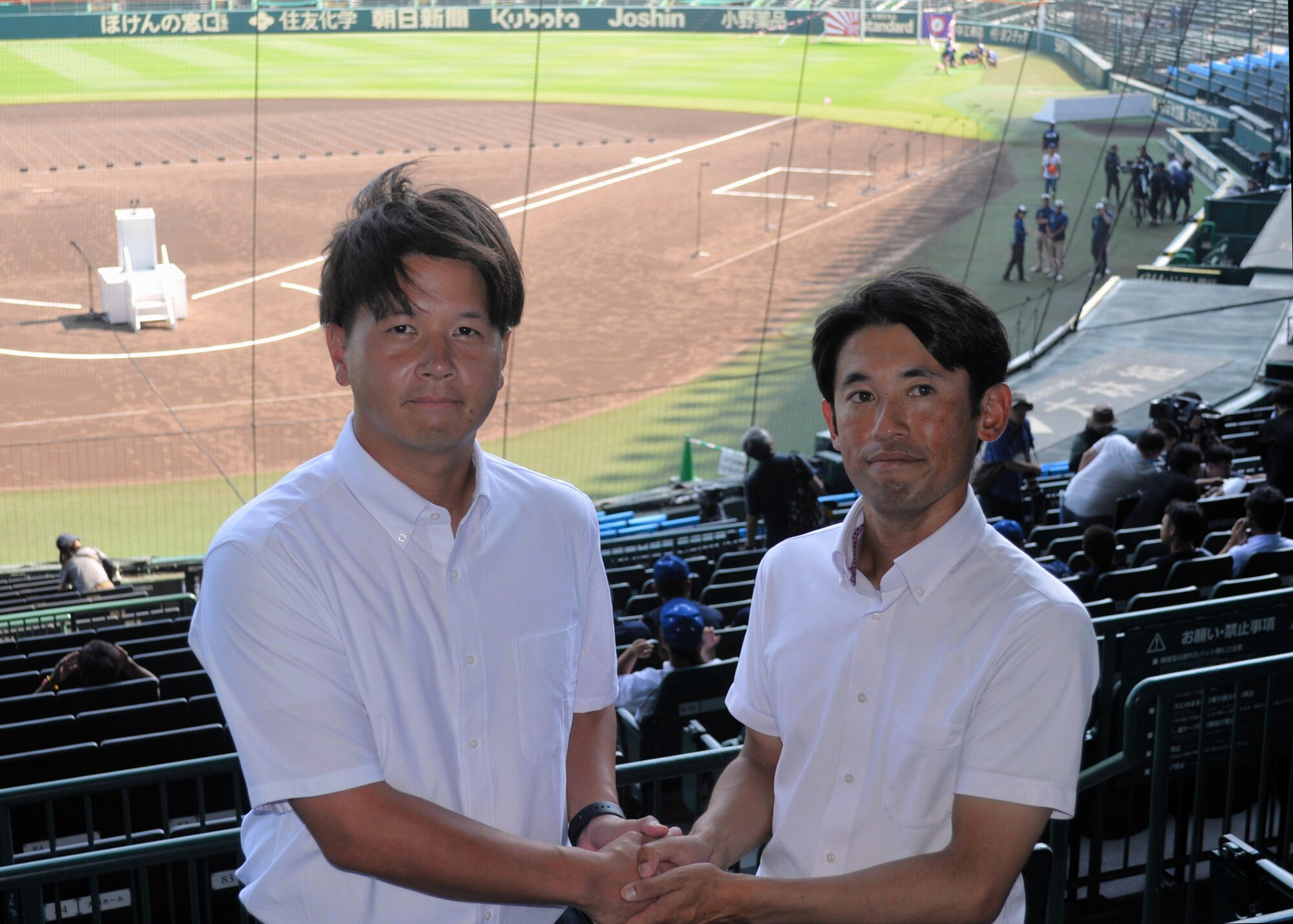 握手する高川学園の松本祐一郎監督(右)と未来富山の角鴻太郎監督=2025年8月4日午後3時20分、阪神甲子園球場、三沢敦撮影