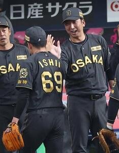 阪神対ヤクルト　藤川球児監督(右)は自身のセリーグ記録の38試合連続無失点を達成した石井大智を笑顔で出迎える(撮影･上田博志)