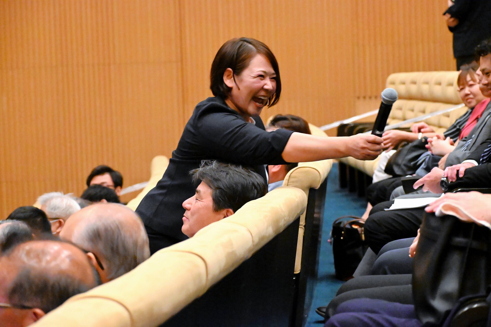 参加者に質問し、マイクを差し出す谷本歩実さん=2025年9月16日、千葉県木更津市のかずさアカデミアホール、八鍬耕造撮影