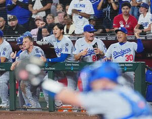 ダイヤモンドバックス対ドジャース　11回、ダイヤモンドバックスを破り、ベンチでガッツポーズを見せる大谷(左から3人目)、ロバーツ監督(右端)(撮影･菅敏)