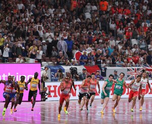 観客が見つめるなか、男子400メートルリレー決勝で第3走者からアンカーにバトンを渡す日本チーム(中央)＝21日、国立競技場