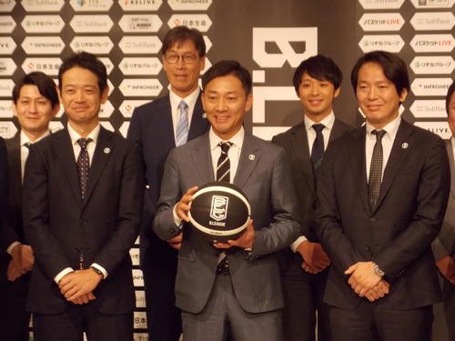 Bリーグ新体制の集合写真で笑顔を見せる島田慎二チェアマン(前列中央)ら(撮影･松本航)