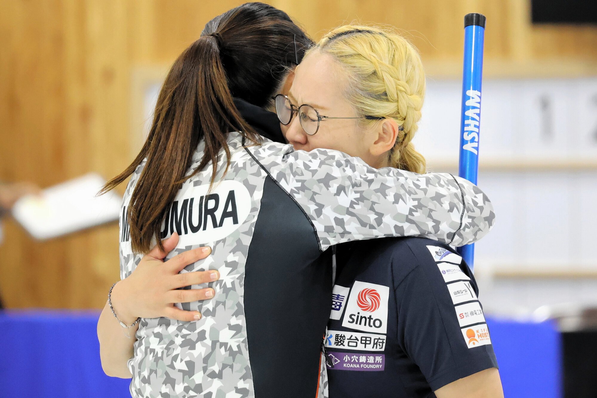 カーリングのミラノ･コルティナ五輪最終予選の代表決定戦で抱擁して互いの健闘をたたえる小穴桃里(とうり)(右)と松村千秋=2025年9月28日、稚内市みどりスポーツパーク、清水優志撮影
