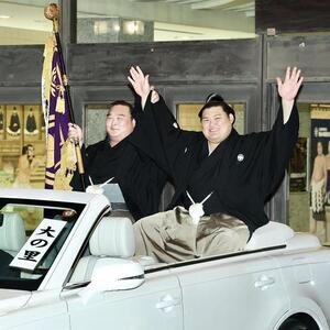 パレード車からファンの声援に応える大の里(右)と旗持ちの白熊(撮影･河田真司)