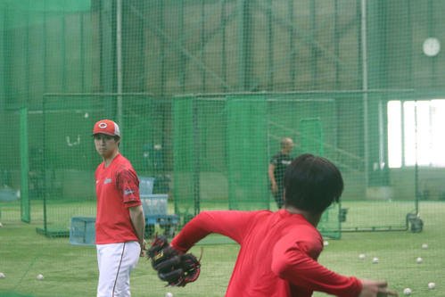 17日、キャッチボールを見つめる広島野村3軍投手コーチ兼アナリスト(左)