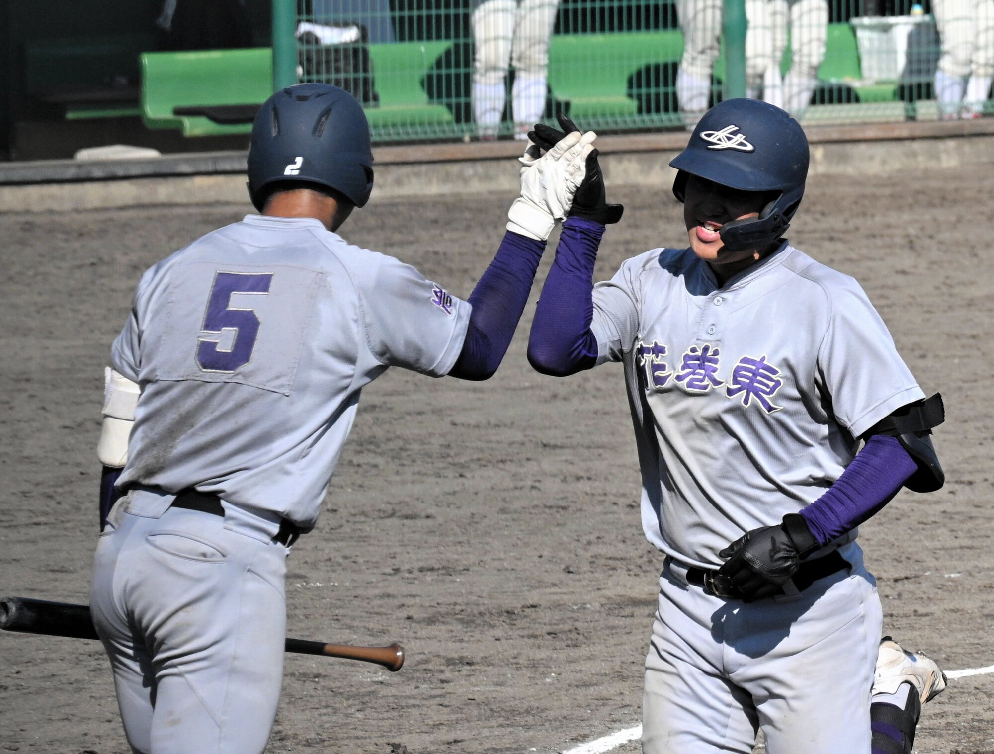 五回、花巻東の赤間史弥選手(右)は同点の2点本塁打を放って本塁にかえり、次打者古城大翔選手とハイタッチ=2025年9月30日、花巻球場、長野剛撮影