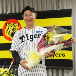 今季限りで現役を引退する阪神原口は花束を手に笑顔を見せる(撮影･上山淳一)