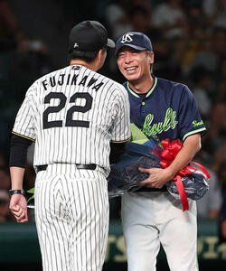 阪神対ヤクルト　藤川監督(左)から花束を受け取る高津監督(撮影･上田博志)