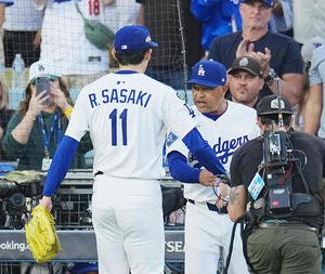 地区シリーズ･ドジャース対フィリーズ　10回の投球を終え、ロバーツ監督(右)に迎えられる佐々木(撮影･菅敏)