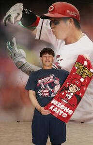 マツダスタジアム正面グッズ売り場の巨大壁面写真がリニューアル。タイトル記念グッズのTシャツを着てポーズを決める小園(撮影･加藤孝規)