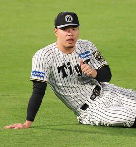 ストレッチ中にサムズアップポーズを見せる佐藤輝(撮影･上田博志)