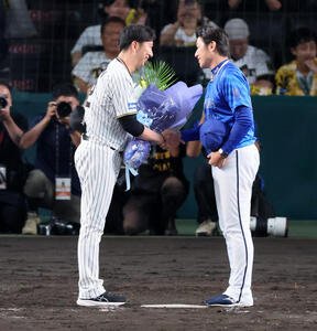 阪神対DeNA　今シーズンで退任するDeNA三浦監督へ阪神藤川監督(左)から花束が贈られた(撮影･加藤哉)