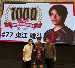 通算1000得点を達成したジークスター東京の東江(中)と記録を祝福するビジョンの前で記念撮影する松山英樹(右)と富樫勇樹