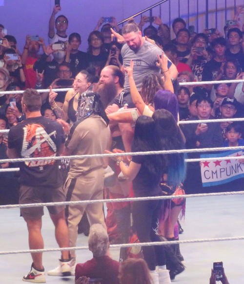 メイン終了後、WWE所属の選手たちに担がれながら日本のファンにあいさつするAJスタイルズ(中央上)