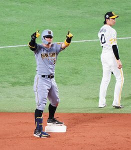 ソフトバンク対阪神　6回表阪神1死三塁、適時二塁打を放った佐藤輝(左)はベンチに向かってポーズ。右は川瀬(撮影･鈴木みどり)
