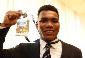 共に天下を！！と栗山英樹日本ハムCBOからのメッセージ入りドラフト会議の会場入場証を掲げる大阪学院大エドポロケイン(撮影･白石智彦)