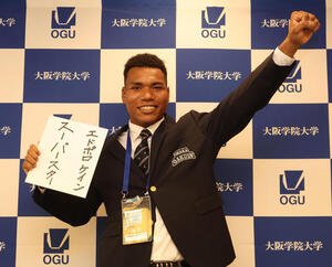 スーパースターと書かれた色紙を手にガッツポーズする大院大のエドポロ　ケイン(撮影･白石智彦)