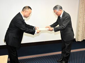 ｢大津高校いじめ調査委員会｣の原村憲司委員長(右)から報告書を受け取る浦本清隆校長=2025年10月31日午前9時36分、熊本市中央区、林国広撮影