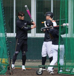 打撃練習中、アクアバットを構える糸井臨時コーチ。右は佐藤(撮影･加藤哉)