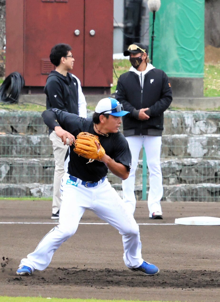 二塁の守備練習で特訓を受ける日本ハムの野村佑希(手前)。新庄剛志監督(右奥)も視察に訪れた