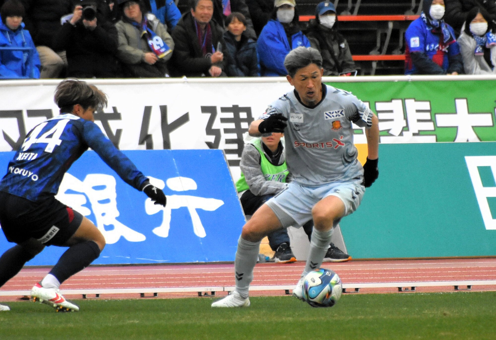 甲府との開幕戦で先発出場した福島の三浦知良(右)は前半20分までプレーした＝7日、甲府市のJITリサイクルインクスタジアム、塩谷耕吾撮影