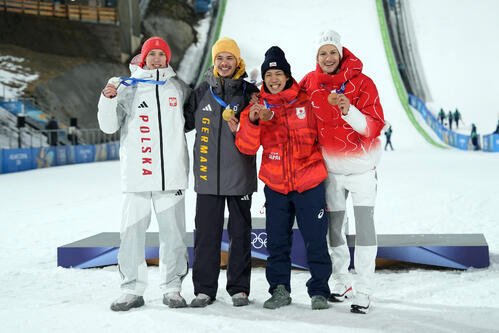 男子個人ノーマルヒルで銅メダルに輝き笑顔を見せる二階堂蓮(右から2人目)。左から銀メダルに輝いたトマシャク、金メダルに輝いたライムント、1人おいて銅メダルのデシュワンデン(撮影･パオロ　ヌッチ)