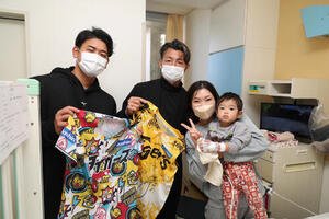 病院を訪問し、患者と家族と記念写真に納まる阪神OBの鳥谷敬氏(中)と岡留(左)