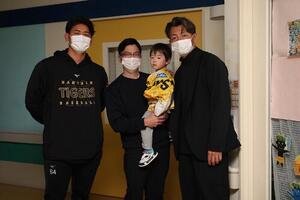 入院患者の児童と記念撮影する阪神岡留(左)と鳥谷氏