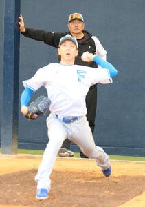 ブルペン入りした日本ハム宮西(手前)をチェックする山本昌臨時コーチ(撮影･木下大輔)