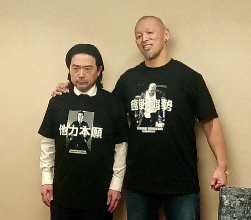 平井代表の首根っこをつかまえてニヤニヤ笑う村上和成