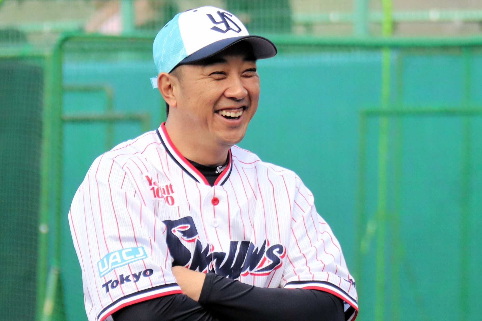 笑顔で練習を見つめるヤクルトの松元ヘッドコーチ=2月3日、沖縄県浦添市