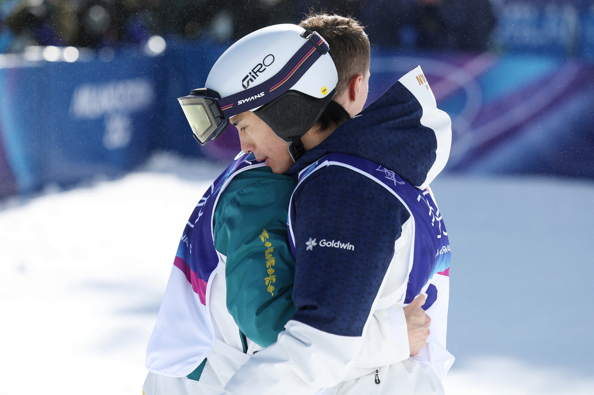 男子デュアルモーグル決勝を滑り終え、3位のマット･グレアムにねぎらわれる堀島行真(手前)=関田航撮影