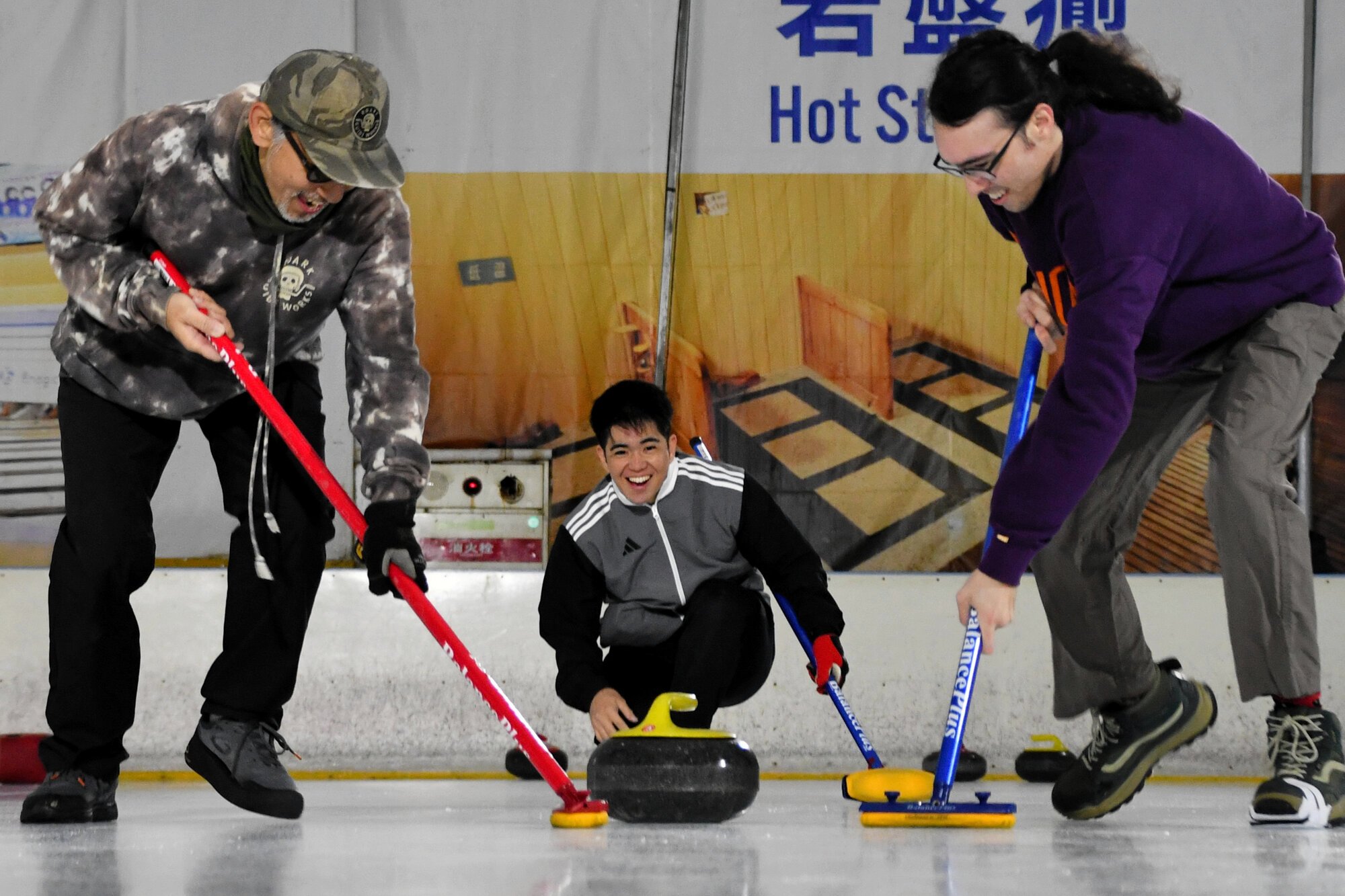 沖縄県でカーリングの普及活動をしている上地雄大さん(中央)と、練習会に参加する人たち=2026年1月17日午前11時29分、沖縄県南風原町、比嘉展玖撮影